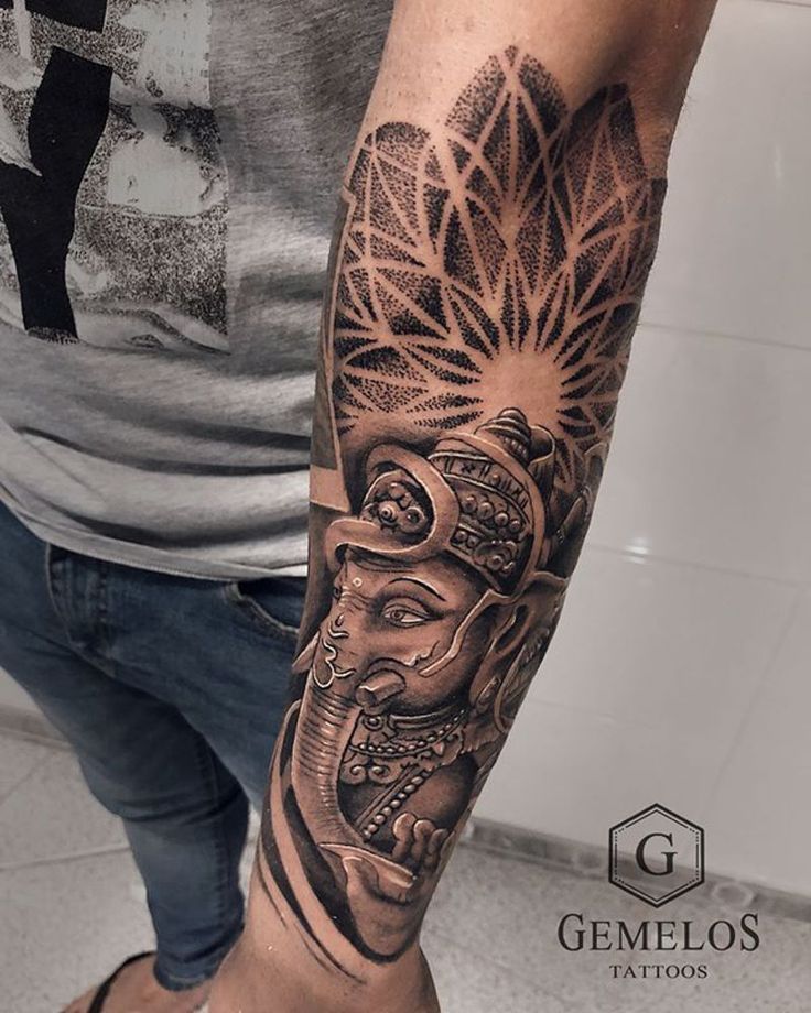 a man's arm with tattoos on it and an elephant head in the middle