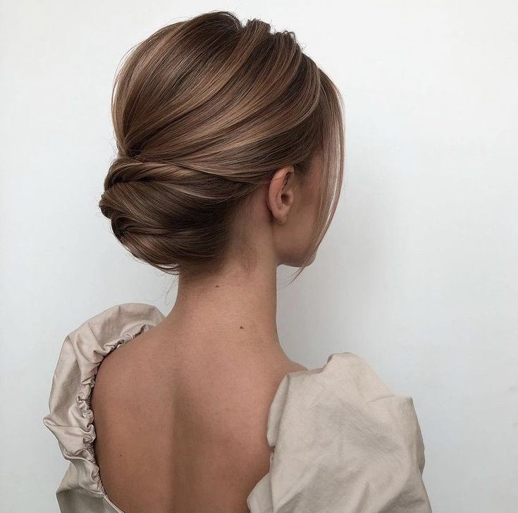 the back of a woman's head, with her hair in a low bun