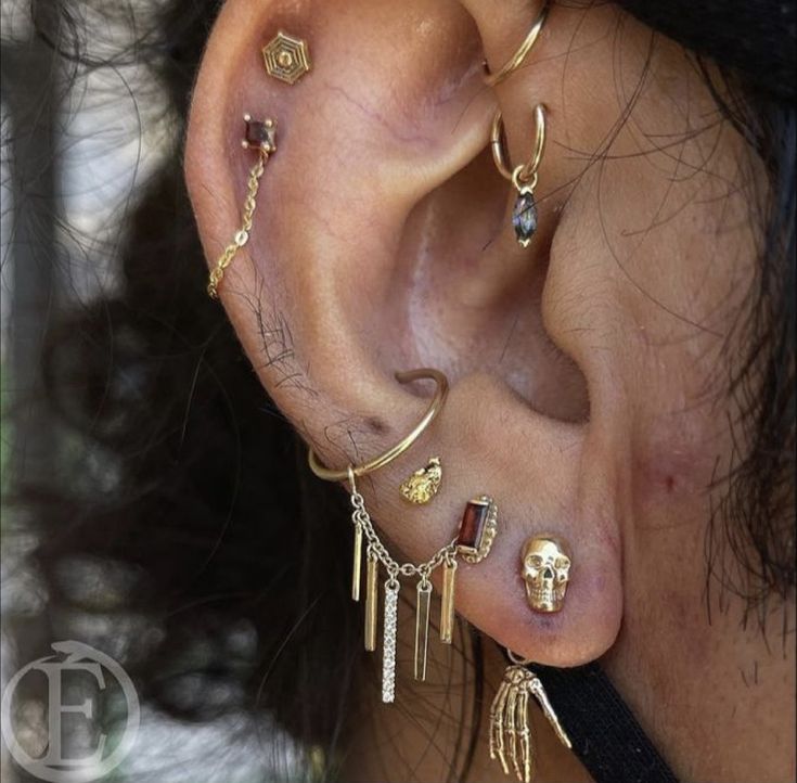 a close up of a person's ear with different types of piercings on it