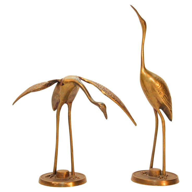 two bronze birds standing next to each other