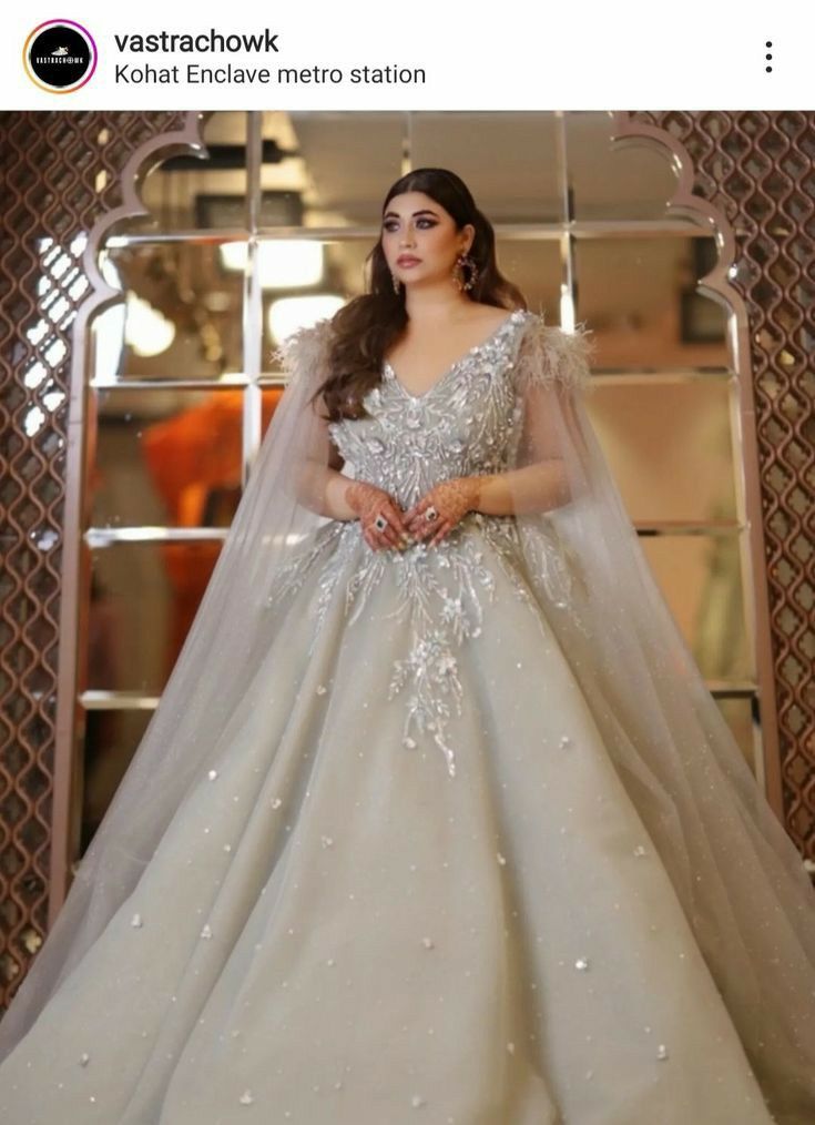 a woman in a wedding dress standing next to a mirror