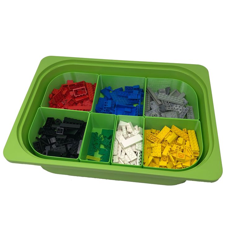 a green tray filled with legos on top of a white table