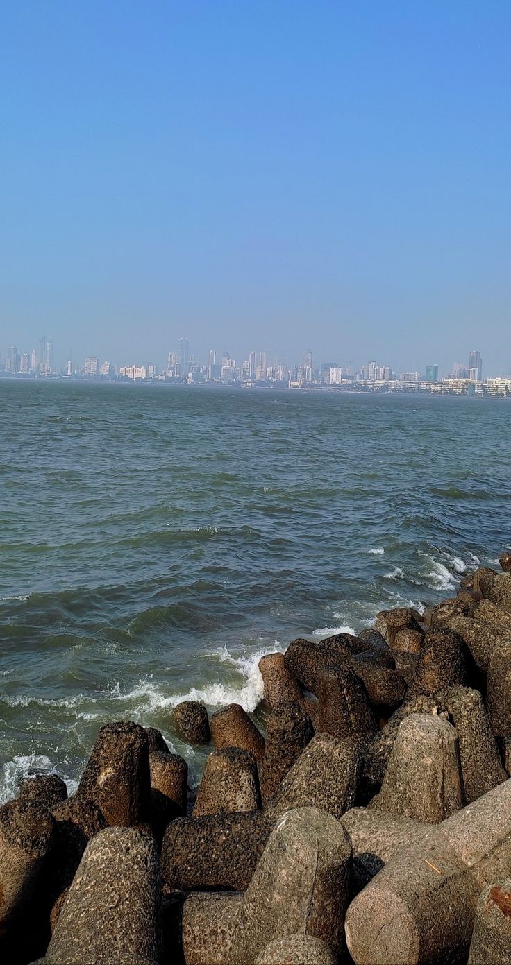 there is a large body of water next to the shore with rocks in front of it