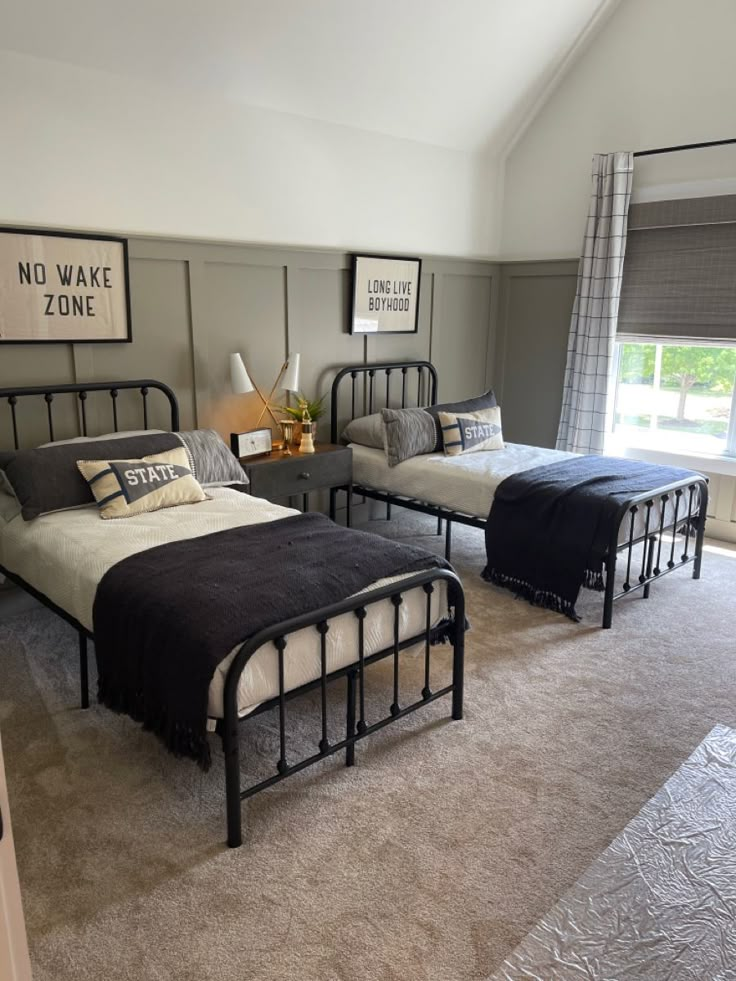 a bedroom with three beds and no wake zone signs on the wall above them, along with carpeted flooring