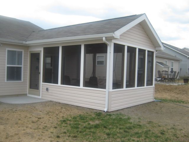 a screened in porch on the side of a house