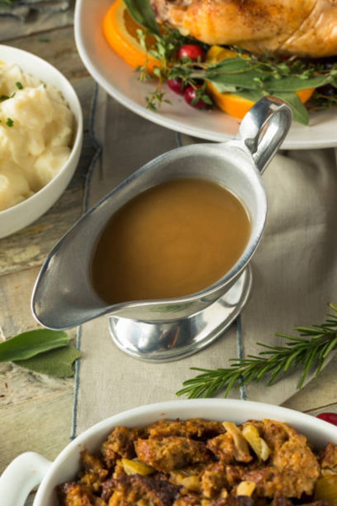 there is a turkey and mashed potatoes on the table with gravy in bowls