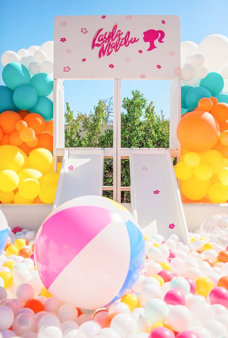 Giant ball pit with double slide and Barbie decals. White, blue, orange, yellow and pink balloon garland. Beach ball inflatables. Scottsdale Arizona Barbie 4th Birthday, Malibu Barbie Birthday Party, Malibu Barbie Party, Barbie Themed Birthday Party, Barbie Pool Party, Barbie Malibu, Barbie Party Decorations, Barbie Theme Party, Barbie Sets