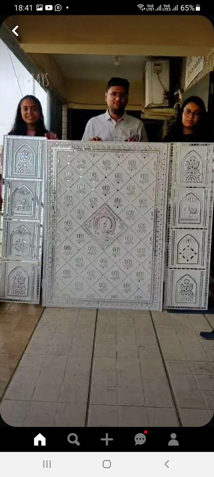 three people are standing behind some decorative tiles