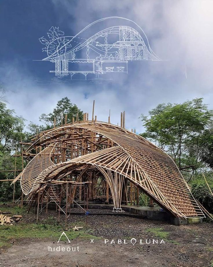 a wooden structure sitting in the middle of a forest with blueprints over it