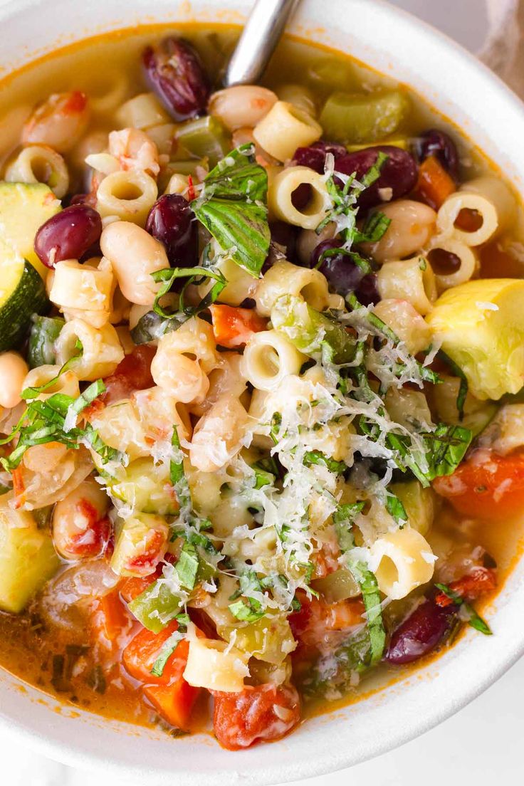 a white bowl filled with pasta and vegetables