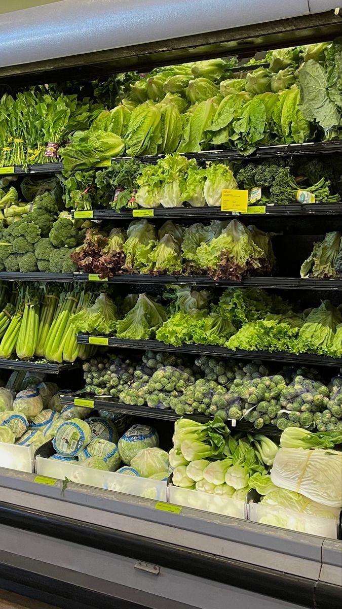 an assortment of vegetables are on display in a grocery store's deli section