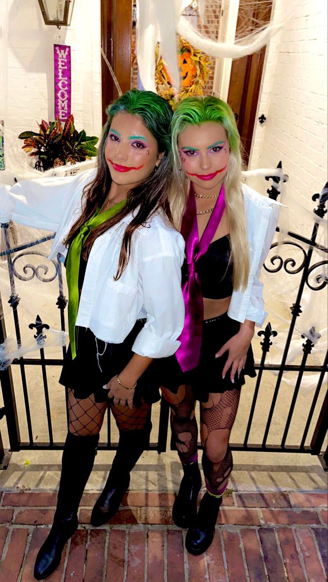 two women dressed in costumes standing next to each other on a brick floor near a gate