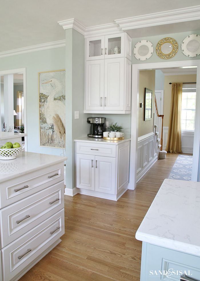 a large kitchen with white cabinets and wood floors