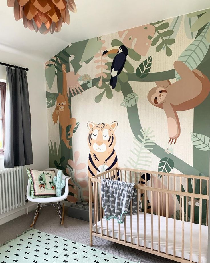 a baby's room decorated with jungle wallpaper and animal themed crib bedding