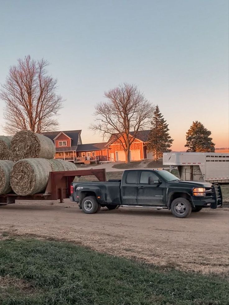 a truck is hauling hay in front of a house