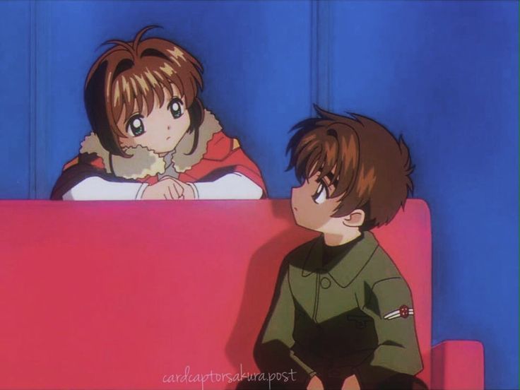 two anime characters sitting on a pink couch in front of a blue wall and one is staring at the camera