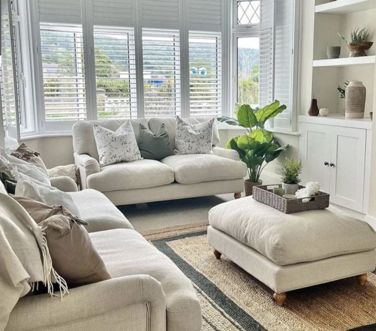 a living room filled with furniture and lots of windows