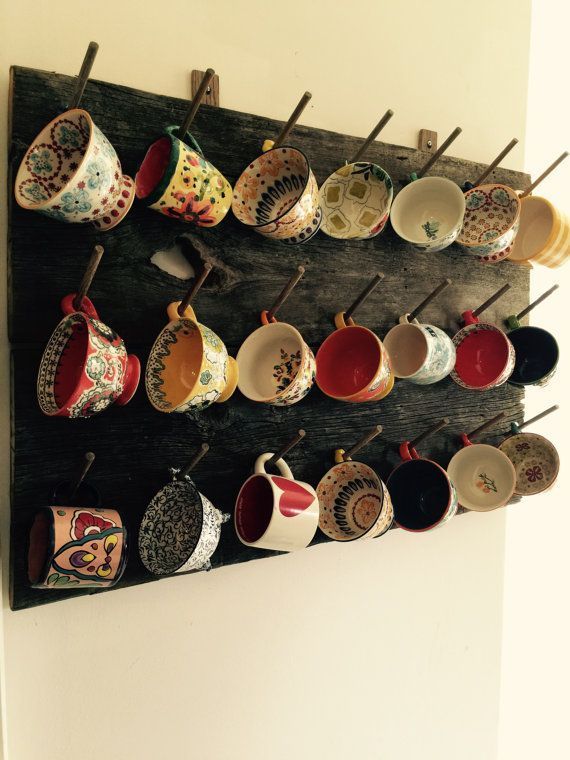 there are many cups hanging on the wall