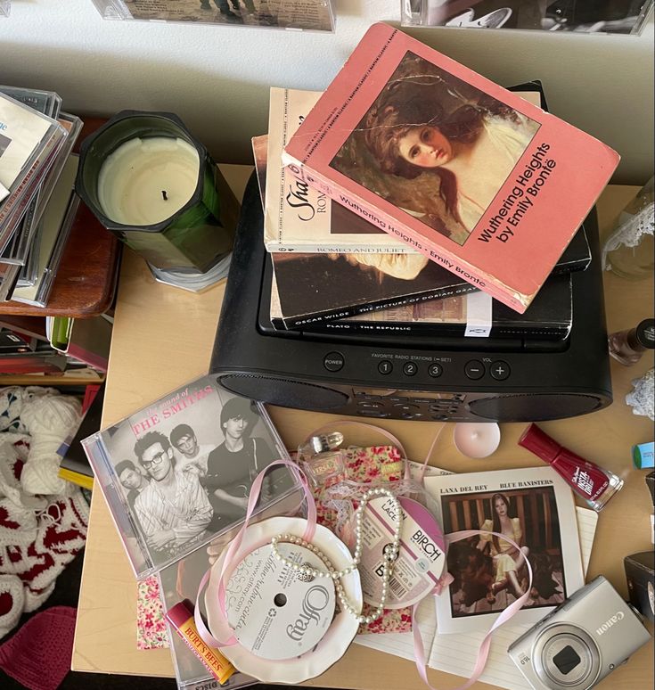 a table topped with lots of books and other items next to a camera on top of it