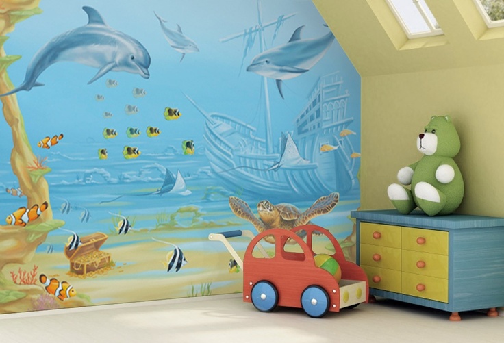 a child's room decorated in blue and green with dolphins on the ocean wall