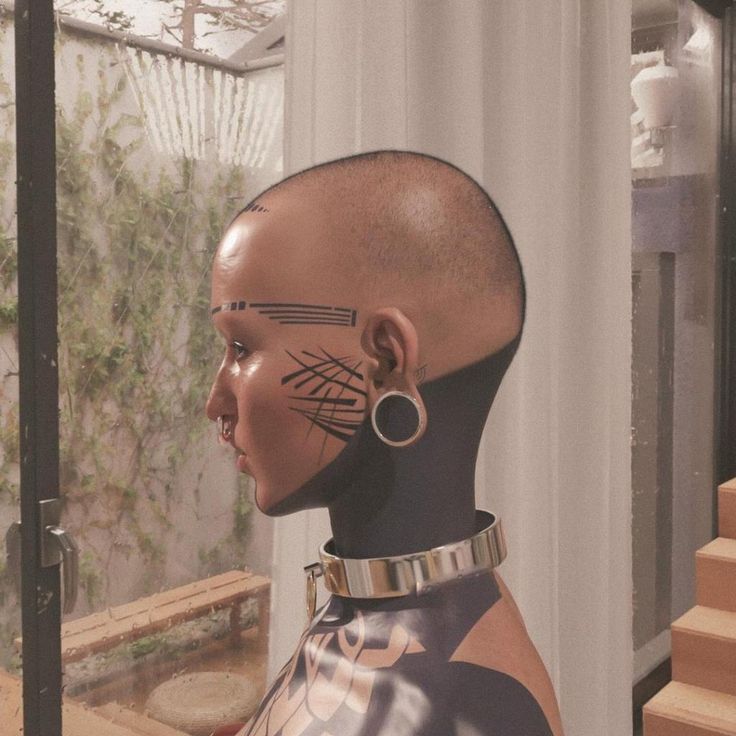 a mannequin head with tattoos and piercings on it's face in front of a window