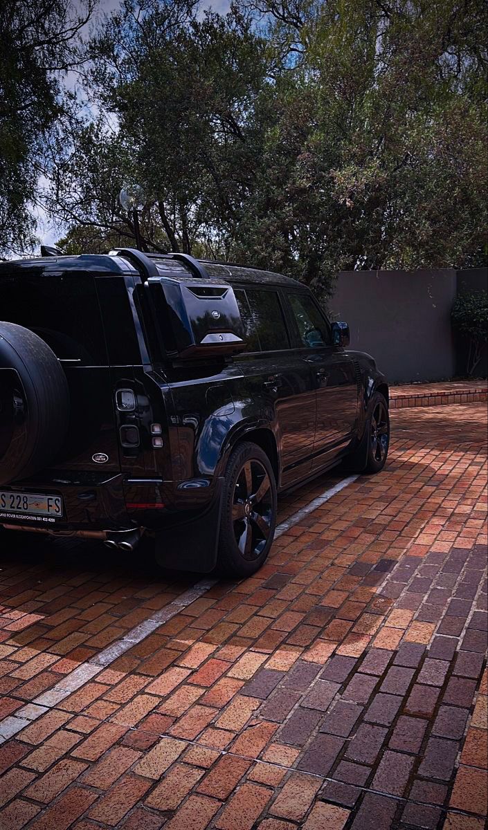 a black suv parked on the side of a brick road