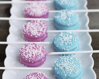 colorful cookies on a white plate with sprinkles are arranged on a wooden table