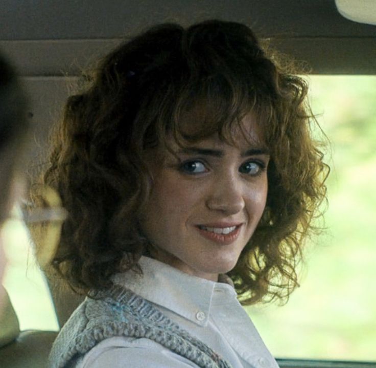 a woman sitting in the back seat of a car with her hand on her hip