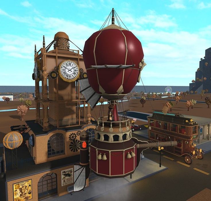 a large red balloon sitting on top of a building next to a train and clock tower