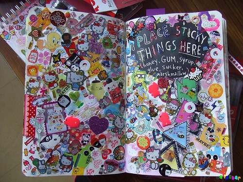 an open book with lots of stickers on the pages and in it's cover