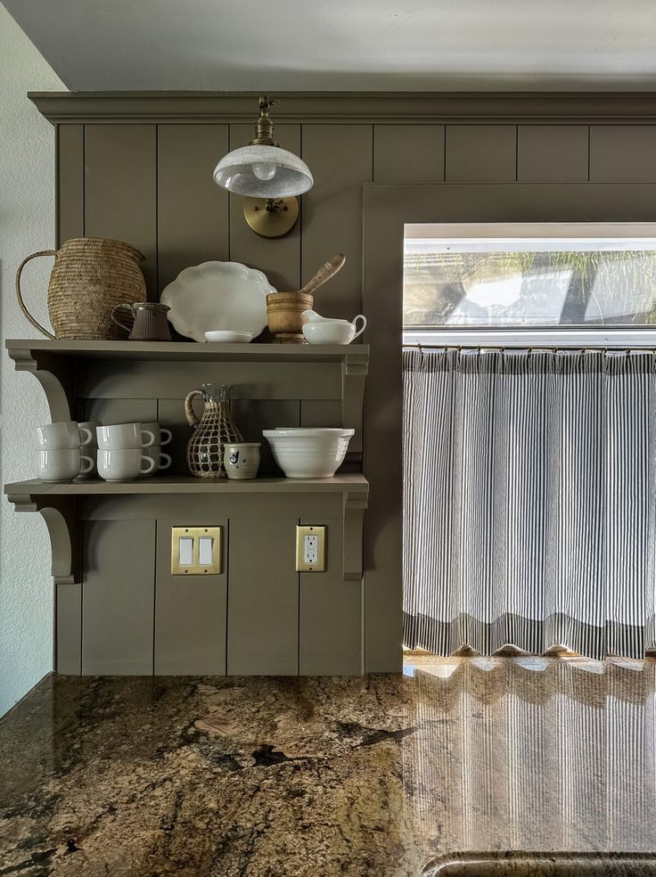 the kitchen counter is covered with dishes and cups