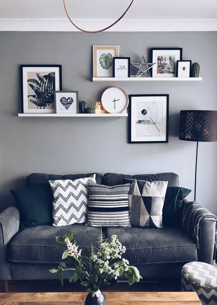 a living room filled with furniture and lots of pictures on the wall above it's coffee table