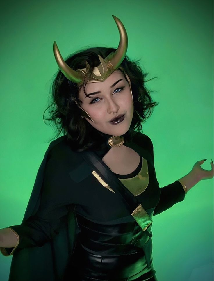 a woman dressed in black and gold with horns on her head