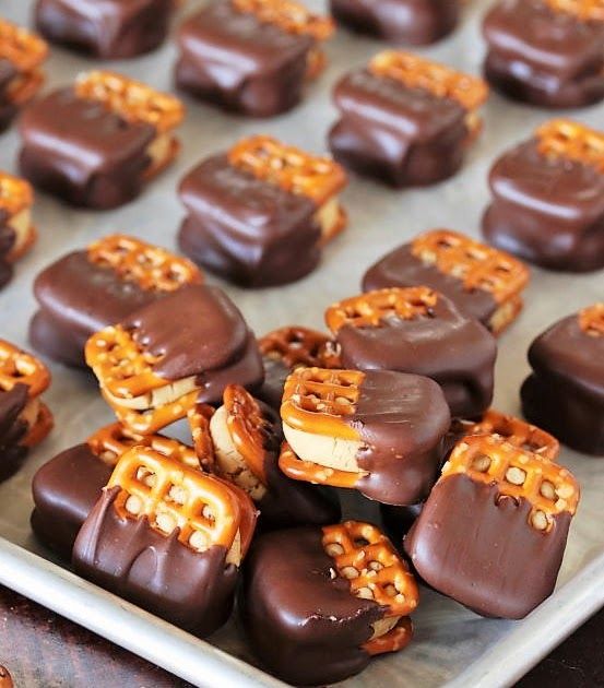 chocolate covered pretzels are arranged on a baking sheet and ready to be eaten