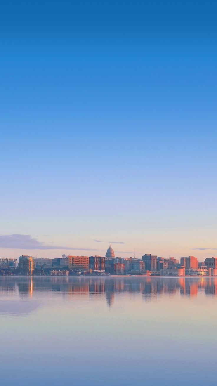 the city is reflected in the calm water