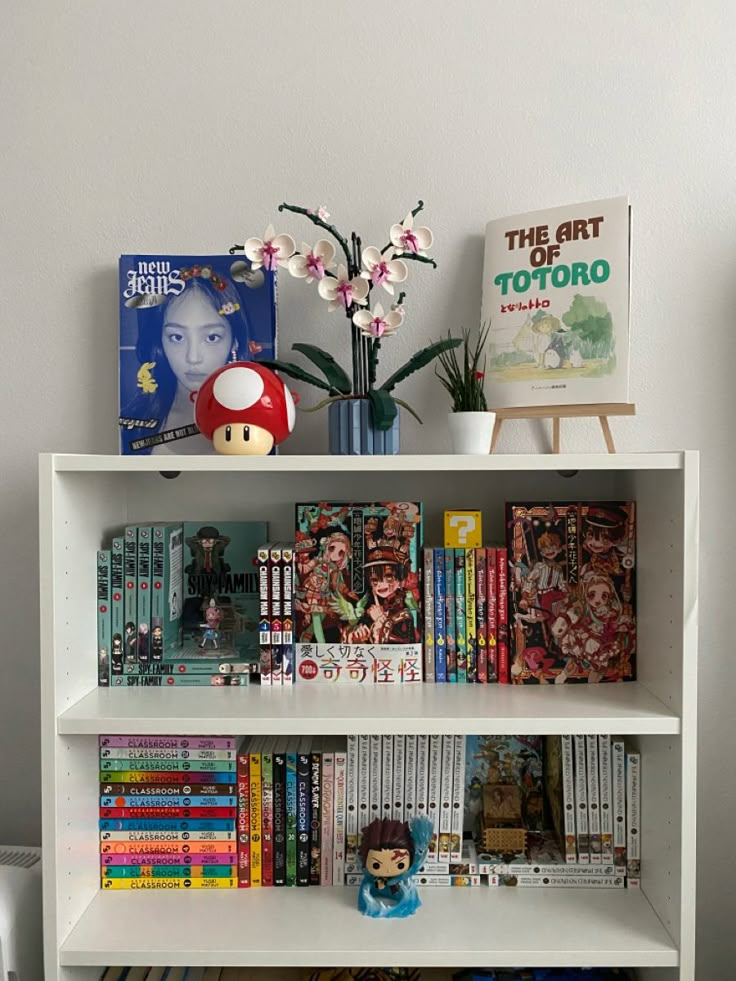 a book shelf filled with books next to a wall mounted poster and stuffed animal toy