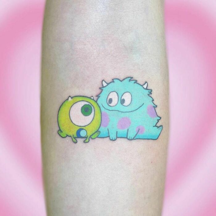 a small blue and green monster tattoo on the leg