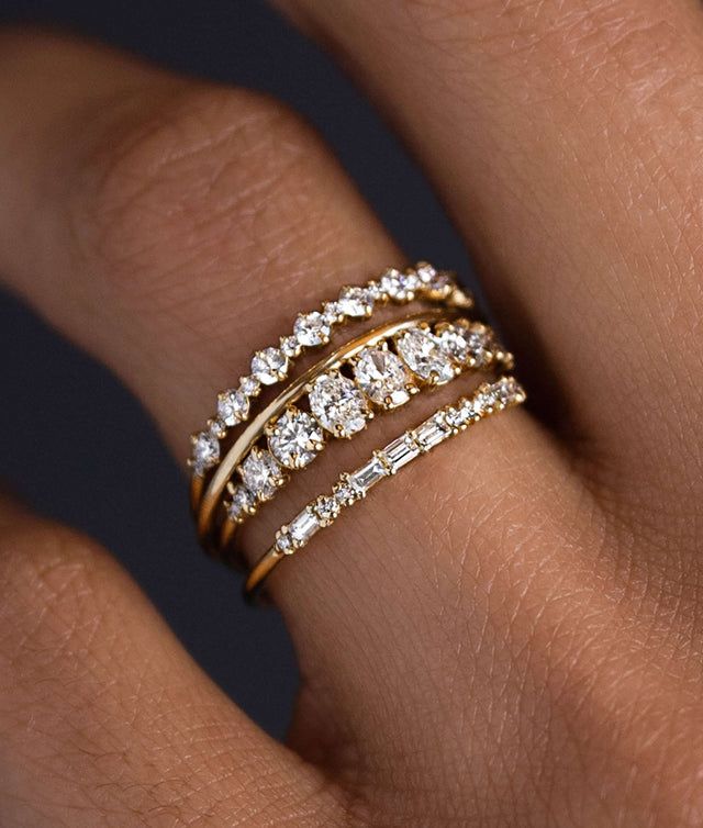 a woman's hand with three different rings on her finger and the ring is gold