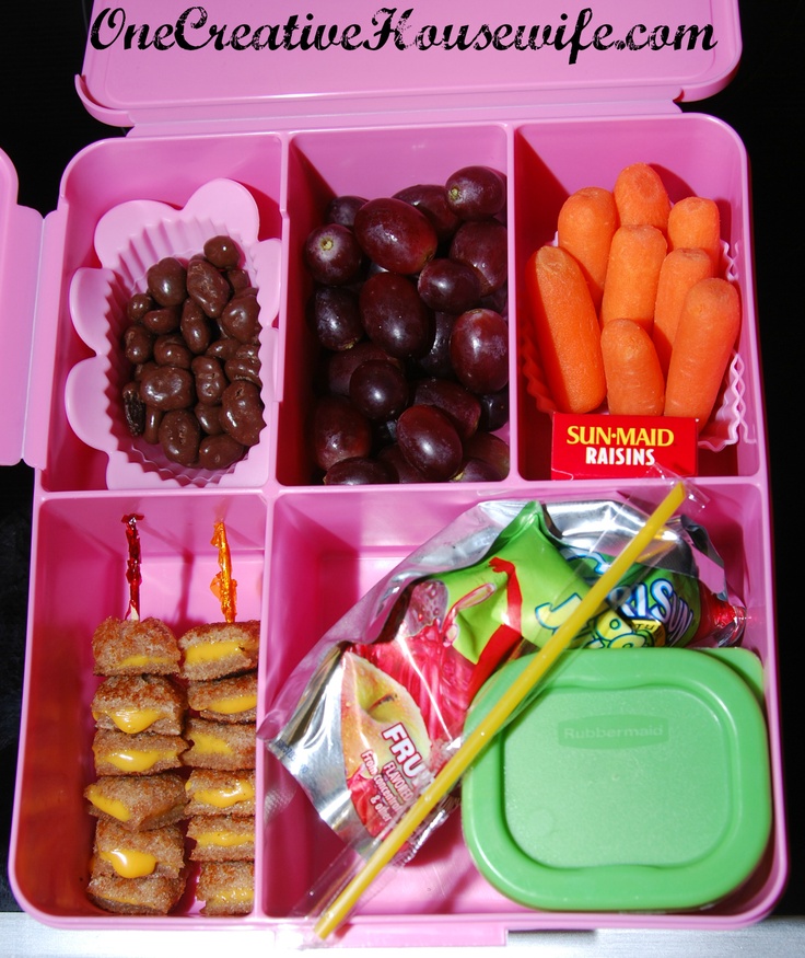 a pink lunch box filled with lots of different food items and candy bars on top of it