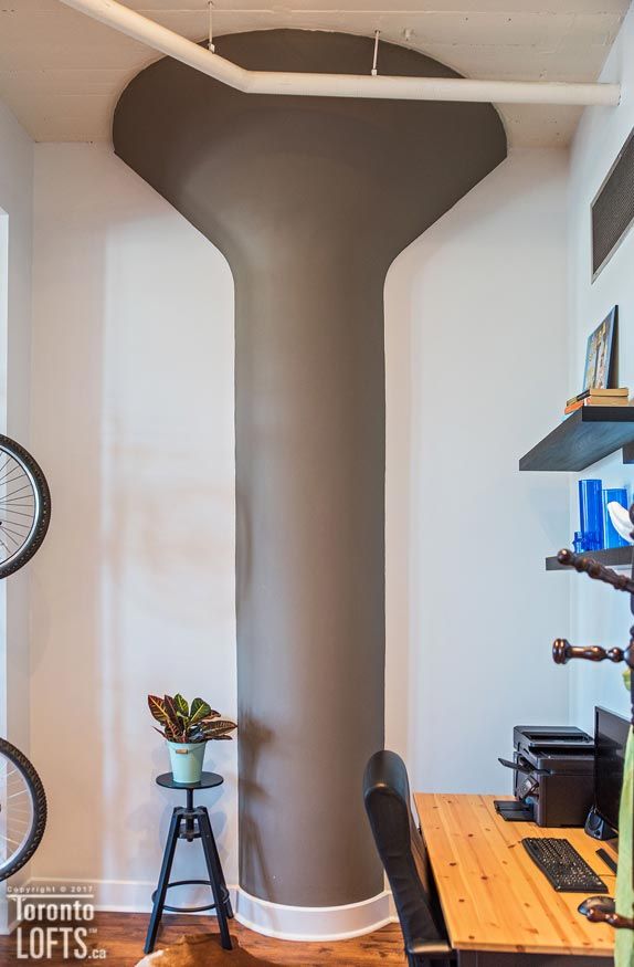 a room with a desk, bike rack and shelves on the wall next to it