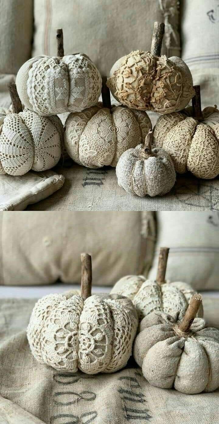 some white pumpkins sitting on top of a bed next to pillows and blankets with crocheted designs