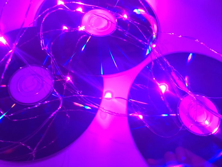 several cd's are lit up with purple lights