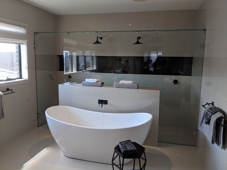 a large white bathtub sitting in the middle of a bathroom next to a window