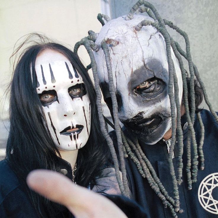 two people with white makeup and dreadlocks are posing for the camera, one is wearing