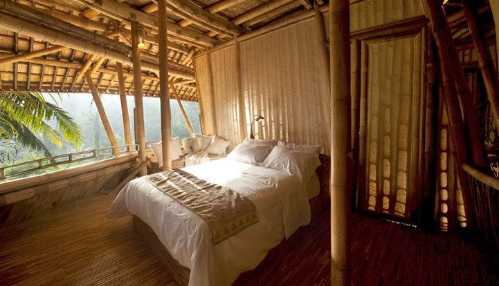 a bed in a room with wooden walls and flooring that looks like it is made out of bamboo