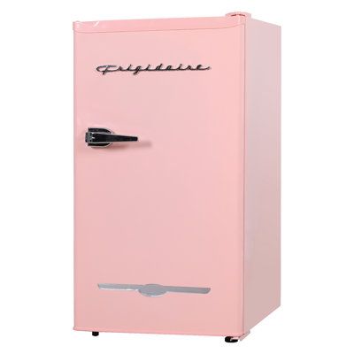 a pink refrigerator sitting on top of a white floor next to a black handle and door