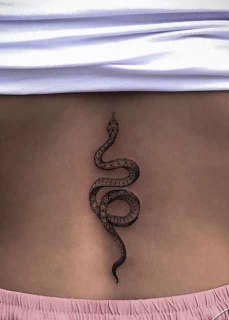 a woman's stomach with a snake tattoo on her belly and the bottom part of her lower back