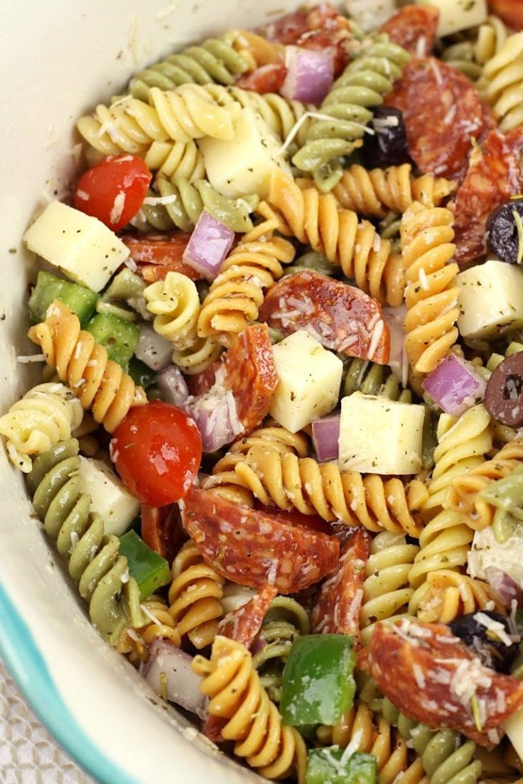 a pasta salad in a bowl with dressing