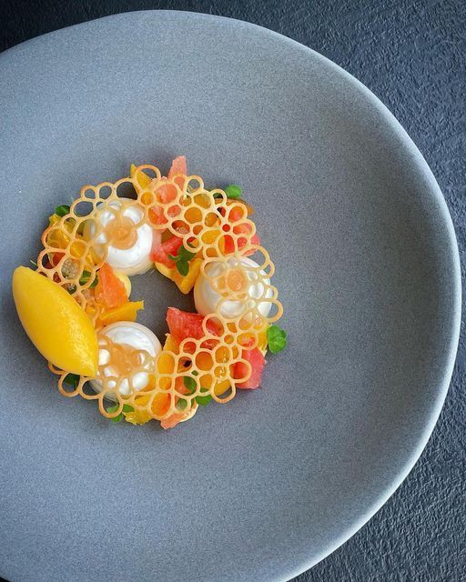 a white plate topped with fruit and veggies on top of a blue table