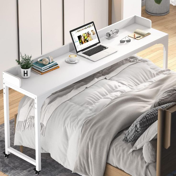 a laptop computer sitting on top of a white desk next to a bed in a bedroom